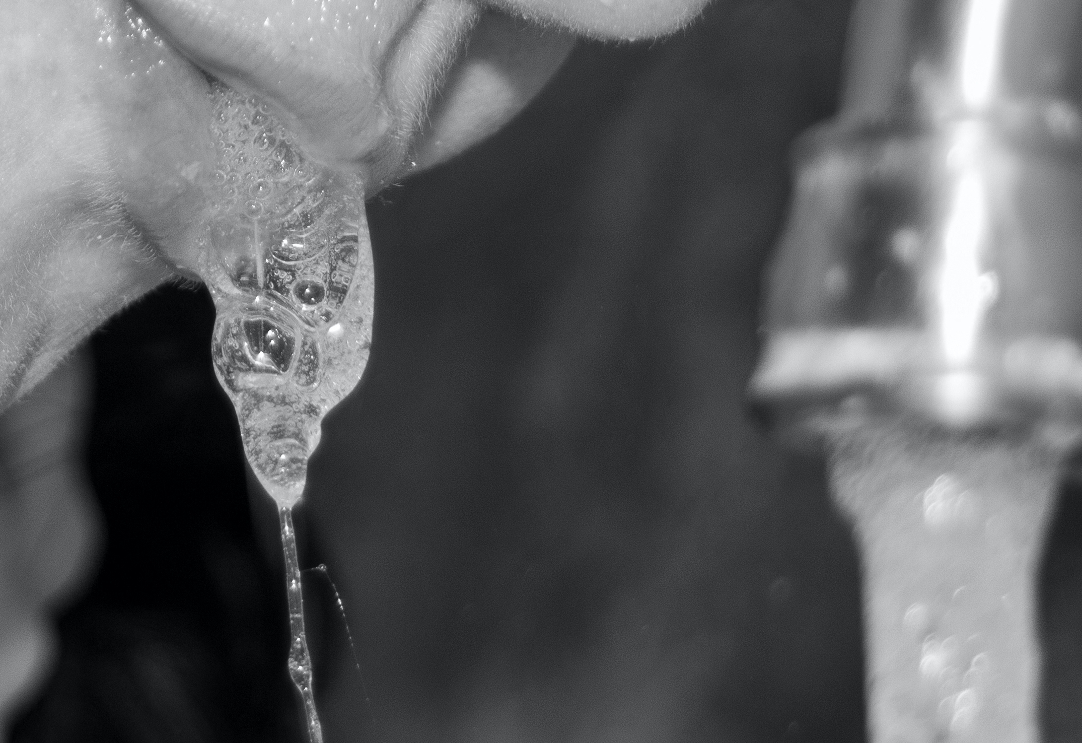 A woman spits into the sink. The faucet was running and there is a tight zoom on the woman's mouth.