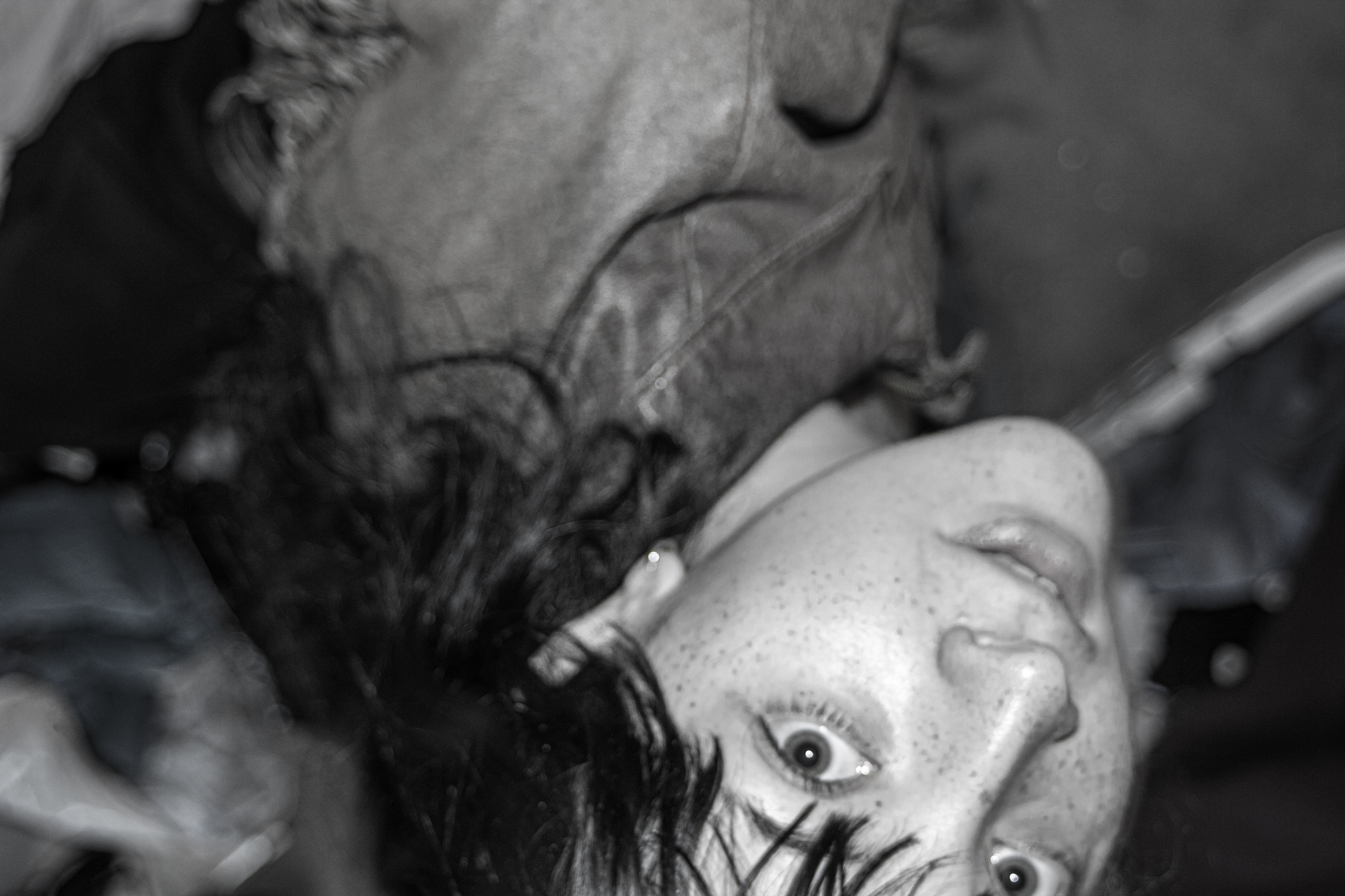 A shot from a woman above on looking at the camera. The photo is in black and white and upsidedown