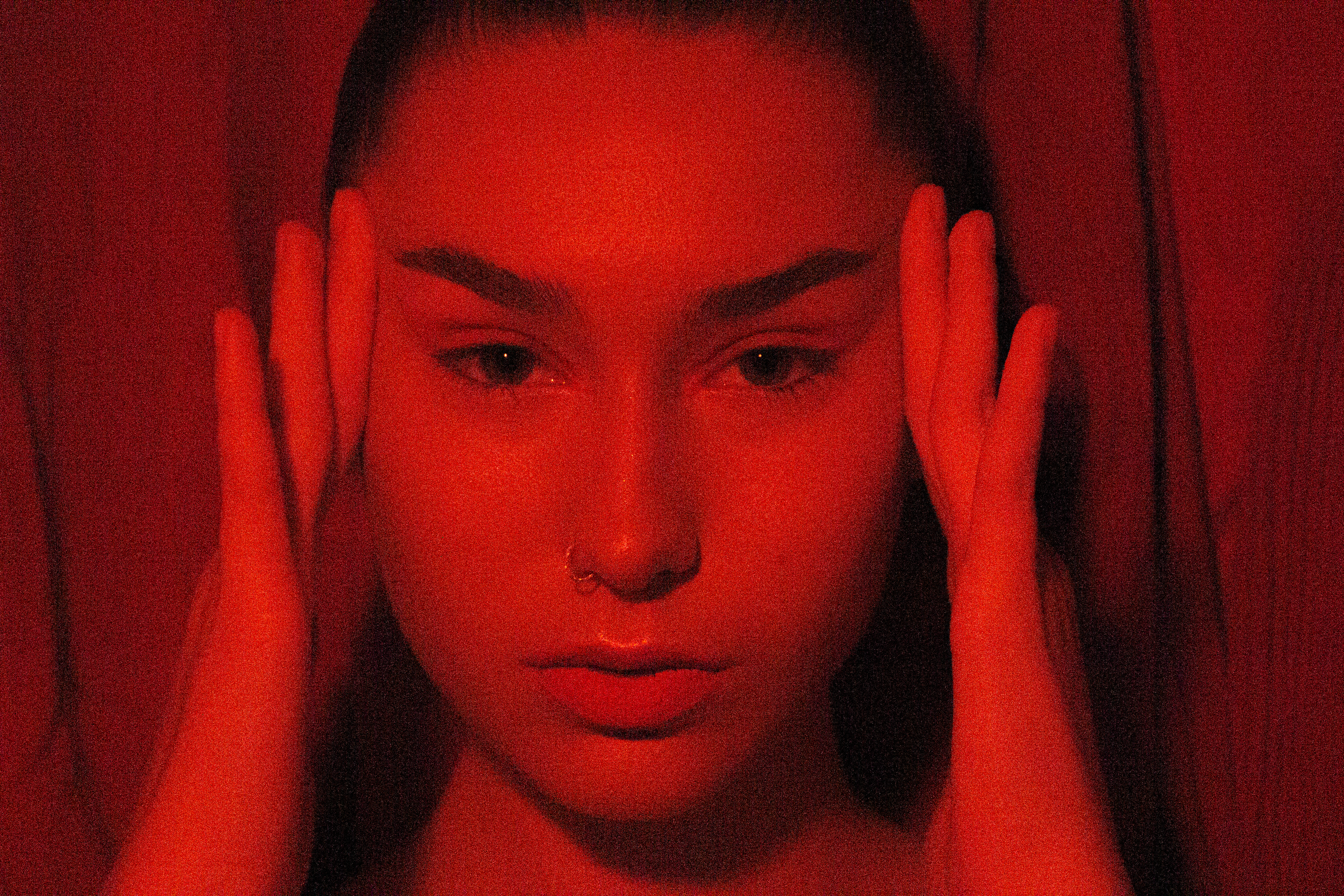 A close up red image of a woman's face. 