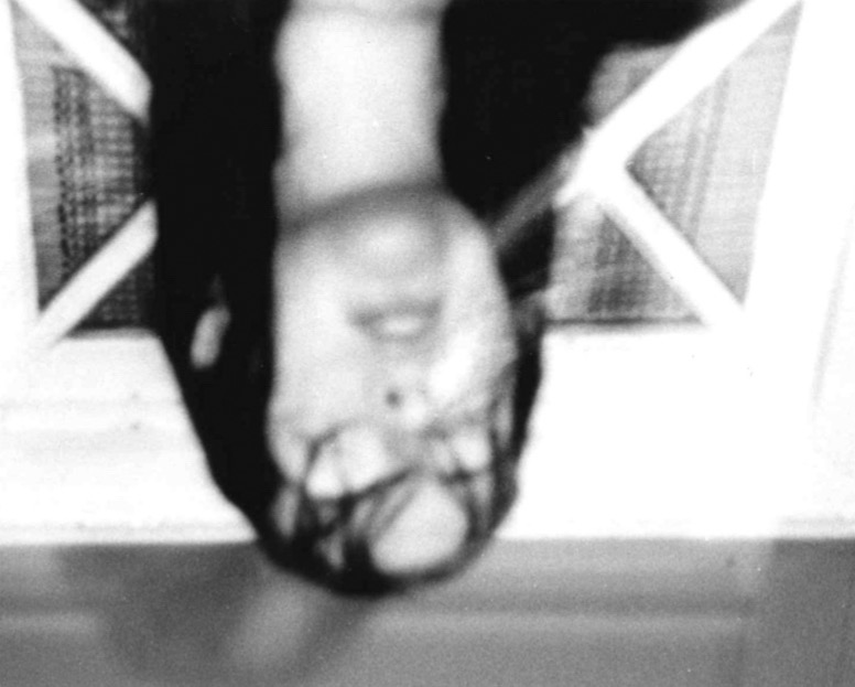 A picture of a woman in the rain. The image only shows her head and neck, it is black and white and upsidedown.